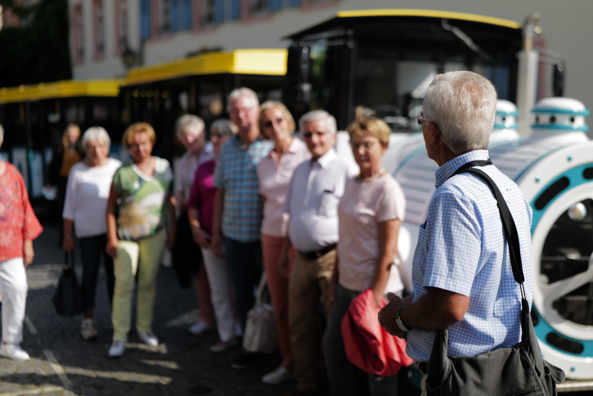 Eine Gruppenführung in Rüdesheim mit dem Winzerexpress im Hintergrund